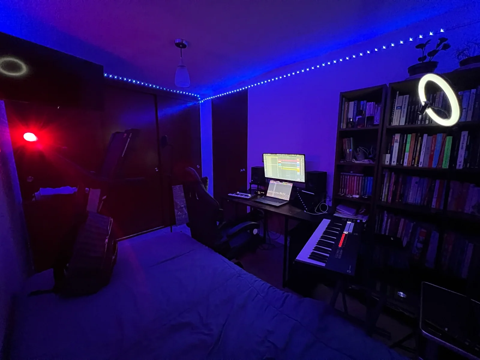 Estudio de Gibran Carmona con teclado, monitores y luz azul y magenta